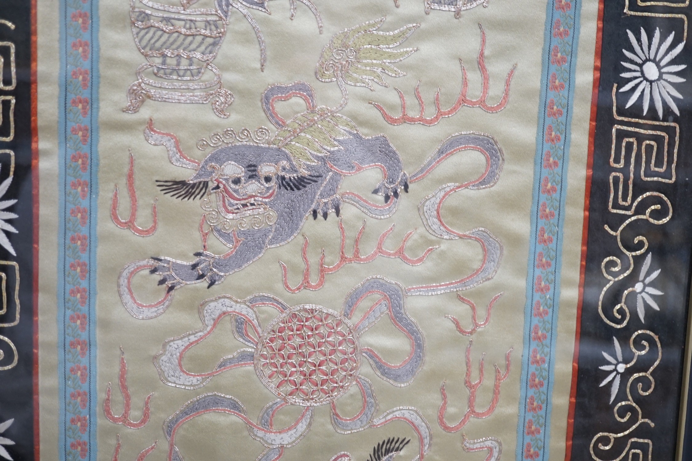 A framed Chinese dragon silk panel. 64 x 34cm